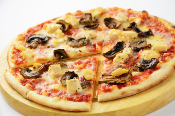 Pizza with mushroom and chicken on round wooden plank, studio isolated