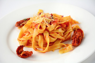 Pasta with sun dried tomatoes and grated cheese,close up isolated image