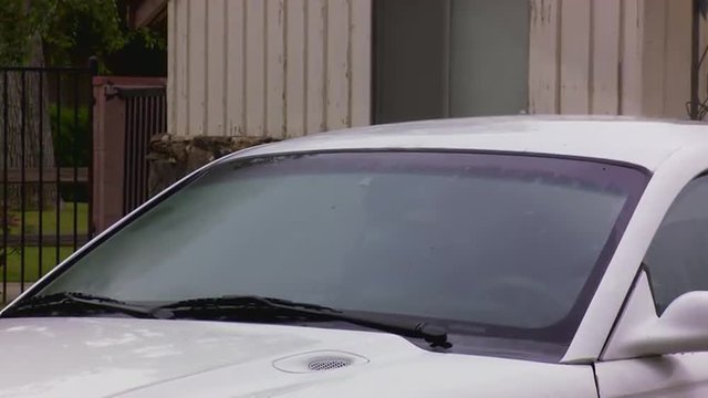 A man destroys his car with a sledgehammer.