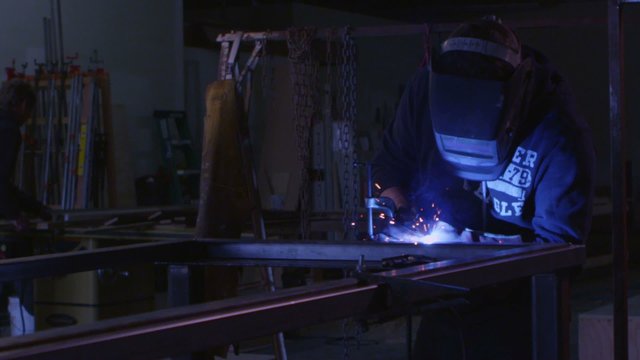 An arc welder welds in a workshop.