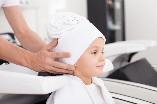 Skilled hairdresser is treating human head after hairwash