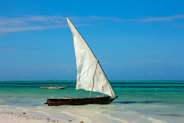 Obraz premium Wooden sailboat (dhow) on a tropical beach of Zanzibar island.