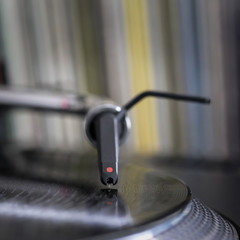 Dj stylus on spinning vinyl, record background