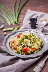 Tabbouleh, an Arabian vegetarian salad made of couscous, tomato, cucumber, onion, garlic, parsley and lemon juice. selective focus