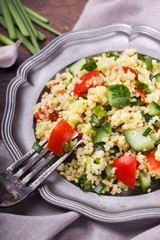 Tabbouleh, an Arabian vegetarian salad made of couscous, tomato, cucumber, onion, garlic, parsley and lemon juice. selective focus