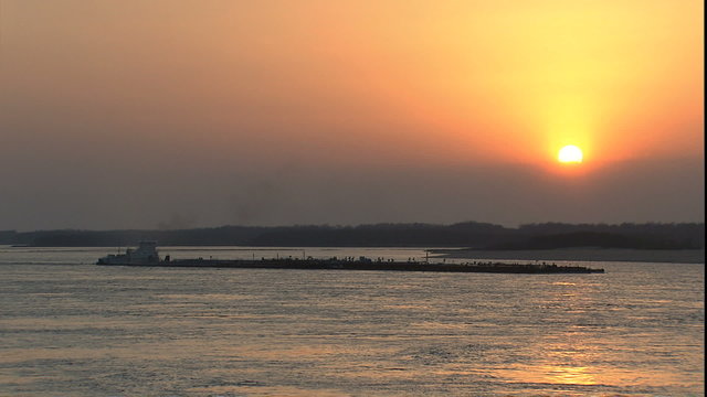 sun setting into fog bank on Mississippi river