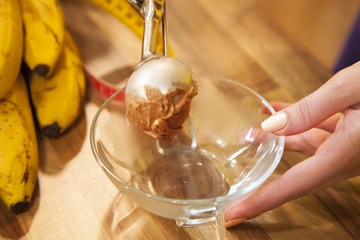 Scooping ice cream into a bowl.