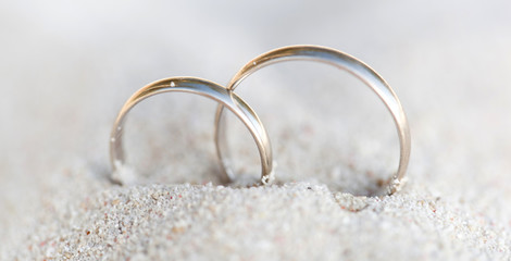 Obraz na płótnie Canvas Wedding rings in sand on beach