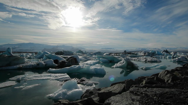 Icebergs melt in the sun  in a vast blue glacier lagoon in the interior of Iceland.