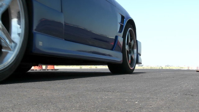 A blue car revs its engine before taking off at  a drifting course in Camarillo California.  