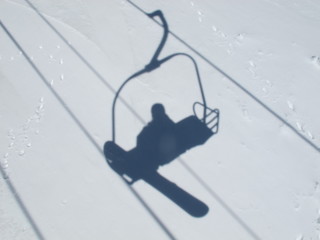 Nature: Ski lift in snow, snowboarder in reflection
