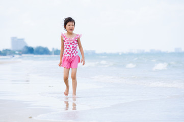 Fototapeta na wymiar Little asian girl walk on the beach