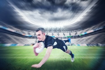 Composite image of a rugby player scoring a try