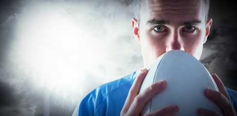 Naklejka premium Composite image of rugby player holding a rugby ball