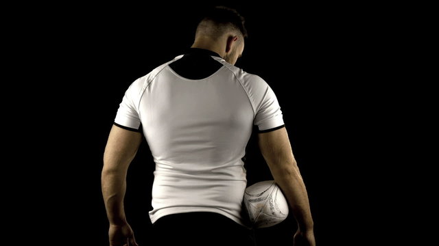 Serious rugby player holds rugby ball