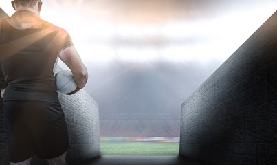 Composite image of rugby player holding the ball