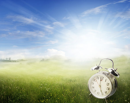 Springtime clock in spring field. Daylight saving