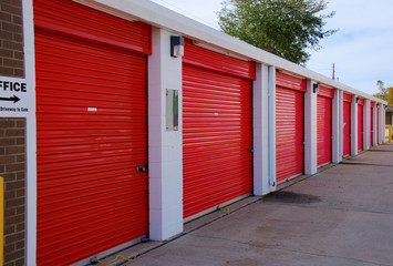 Long row of numbered storage units that are locked with pad locks.