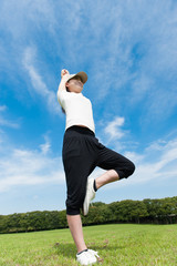 芝生の上でヨガのポーズをしている女性