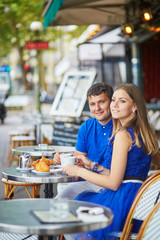 Beautiful young dating couple in Parisian cafe