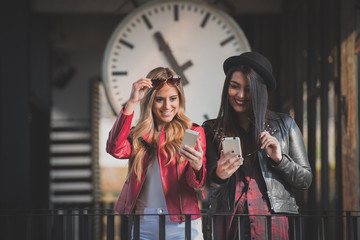 Two women sharing pictures on their smart phones