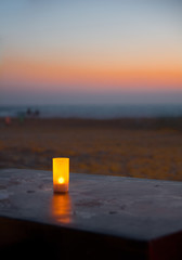 Candle on a beach sunset