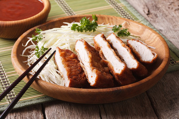 Japanese tonkatsu breaded deep fried pork with cabbage and sauce 
