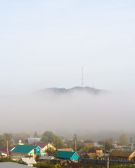 View of the village under hill in fog