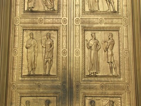 Close view of the historic figures carved into the bronze  doors at  the west entrance Supreme Court.