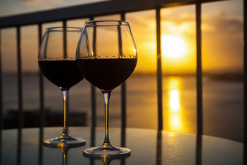 Two glasses with red wine in sunset
