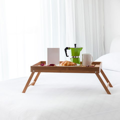 Breakfast tray with coffee on bed
