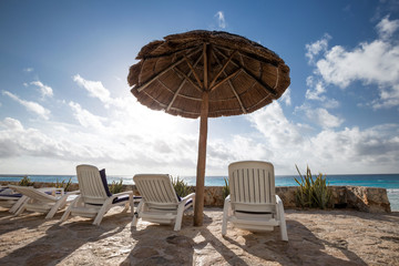 Caribbean beach with grass umbrellas and beds