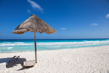 Caribbean sea coastline with grass sun umbrella and wooden beach