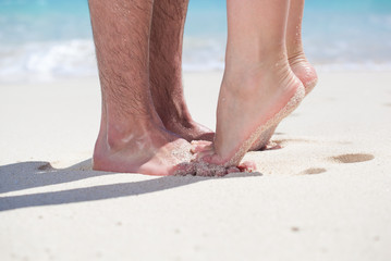 Couple of male and female legs on beach