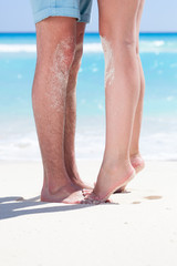 Couple of male and female legs on beach