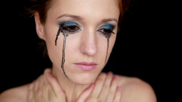 Sad young woman with smeared mascara on face