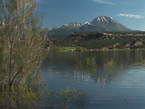 Medium-shot of the Recapture Lake in Utah and the San Juan Mountain.