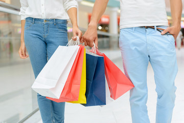 Positive couple holding packages 