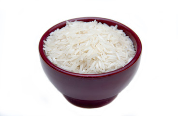 Bowl with uncooked rice on white background