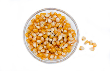 Bowl of dried corn kernels on a white background seen from above