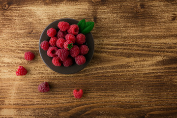 raspberries in bowl on wood  table