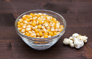 Maize grain dried with popcorn beside on wooden table