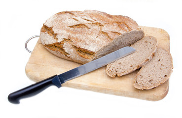 Bread on cutting board with a knife on white background