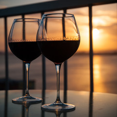 Two glasses with red wine in sunset