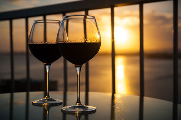 Two glasses with red wine in sunset