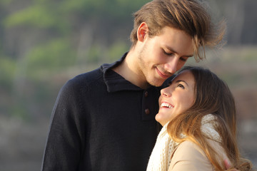 Happy couple hugging in love outdoors