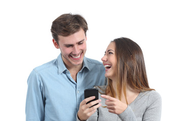 Happy friends laughing and watching a smart phone