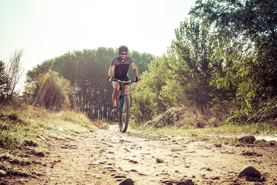 Man riding on a dirty road on a mountain bike