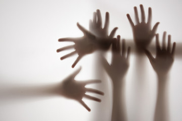 shadow of a hands behind transparent paper