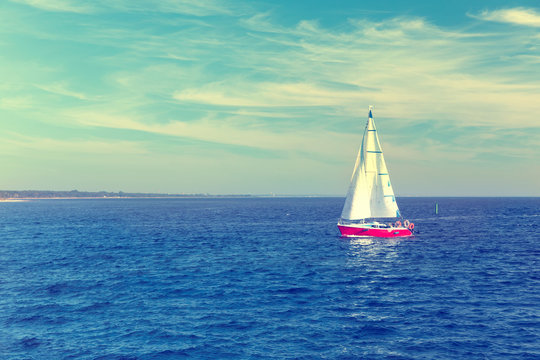 Seascape with sailboat the background of the blue sky and ocean.